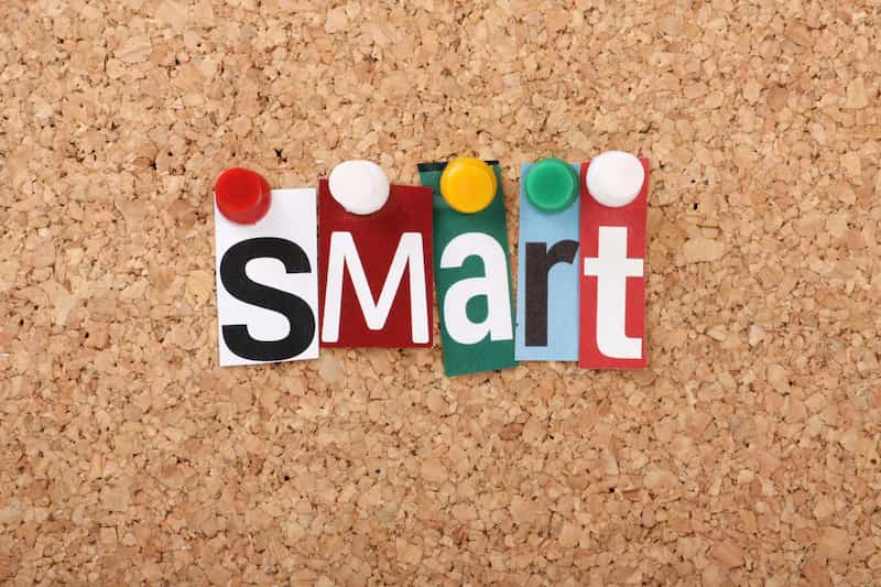 a cork noticeboard with letters pinned to it spelling 'SMART'.