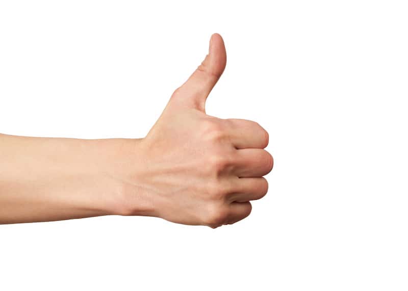 a human hand performing the thumbs up gesture on white background.