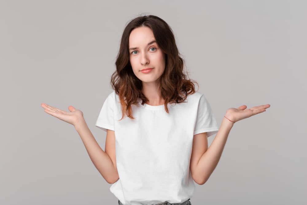 Lady shrugging shoulders to indicate confuion.